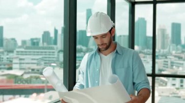 Profesyonel mühendis gökdelen manzarasına bakarken gülümsüyor. Sıradan giyinen yetenekli bir mimar, şehir manzaralı panorama penceresinin yanında dururken plan yapıyor. İzleme