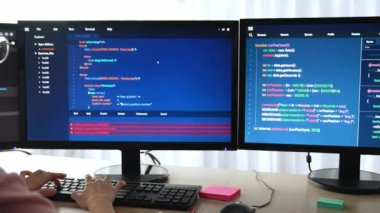 Yavaş çekim arkası yazılım geliştirici mühendisi bilgisayar programlama için birlikte çalışarak hata ayıklama kodunu çözüyor, ofiste monitörde karmaşık algoritmaları çözüyor. Filizlenen