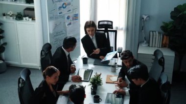 Toplantı odasındaki tabletin mali istatistik tablosuna bakan müdürün üst görüntüsü. Yatırım verilerini analiz etmek ve mali strateji planlamak için birlikte çalışan bir grup iş adamı. Müdürlük.
