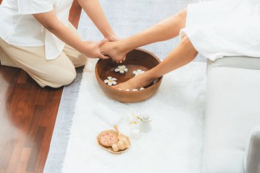 Kadınlar lüks spa salonlarında keyifli ayak masajlarına devam ederken, masör de hafif gün ışığı atmosferinde refleksoloji terapisi veya otel ayak spa 'sında. Sessiz.