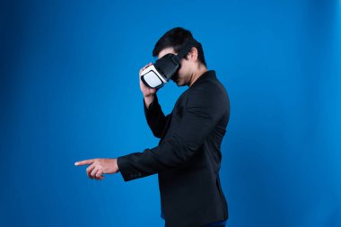 VR kulaklık takan profil işadamı ilginç mavi arkaplanlı fütüristik analitik iletişim teknolojisi sanal gerçekliğini izole etmek için metaevreleri birbirine bağlamaya çalışıyor. Entrika.