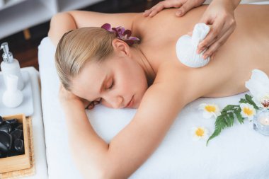 Sıcak bitkisel top spa masaj vücut tedavisi, masör kadın vücuduna nazikçe şifalı bitki torbası bastırıyor. Aromaterapi dinlenme sükuneti ve sükuneti kaplıca salonundaki atmosferi aydınlatıyor. Sessiz.