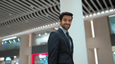 Beyaz arka planda dururken kameraya bakan bir iş adamı. İş elbisesi giyerken kameraya gülümseyen başarılı adamın yakın çekimi. Yönetici, kameraya bak. Hareket eden kamera. Sevinçli..