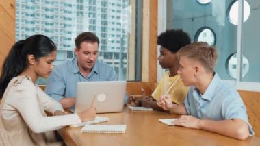 Zeki kız, sınıf çalışmasında çeşitli öğrenciler çalışırken öğretmenine fikir sorar. Sınıfta mutlu çocuk fikri paylaşırken çok kültürlü çocuklar dizüstü bilgisayarı işaret ediyorlar. Öğretim