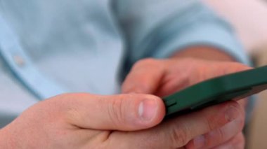 Orta yaşlı bir adam oturma odasındaki koltukta oturur telefon arama verilerini kullanır çocukları iyi bir yetişkin baba ya da eğlence olarak yetiştirir. İşadamı teknolojiyi kolaylık için kullanır. Uyumsuzluk.