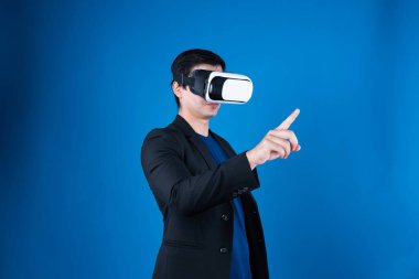 VR kulaklık takan profil işadamı ilginç mavi arkaplanlı fütüristik analitik iletişim teknolojisi sanal gerçekliğini izole etmek için metaevreleri birbirine bağlamaya çalışıyor. Entrika.