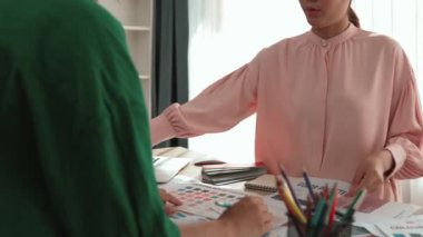 Yavaş çekim iki tasarımcı beyin fırtınası yapıyor ve grafik tasarımı için renk seçiyor ya da istemci renk bozukluklarını tasarımcı bürosundaki kromatik konsültasyonla karşılaştırıyor. Değiştirilmiş