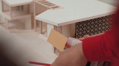 Mimari ekipman kullanarak yavaş çekim ev tasarımcısı bir plan çizerken, iç mimari tasarımcı da müşterilerin talebine göre renk örneklerinden uygun renkler seçiyor. Değiştirilmiş