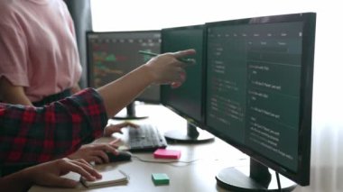 Yavaş çekim arkası yazılım geliştirici mühendisi bilgisayar programlama için birlikte çalışarak hata ayıklama kodunu çözüyor, ofiste monitörde karmaşık algoritmaları çözüyor. Filizlenen