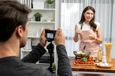 Kameraman, şef etkisinde olan kadına makarna pişiren, domates soslu spagetti hazırlayan, içerik tarifini saran, modern stüdyoda özel sağlıklı yemekler sunan bir kayıt yapıyor. Varsayım.