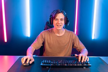 Kazanmak için çevrimiçi oyun oynayan akıllı flama makinesinin sunucu kanalı, neon ışıklı odada seçilen takım yarışması için izleyicilerle birlikte canlı yayında canlı yayında kulaklık takıyor. Bireysel.