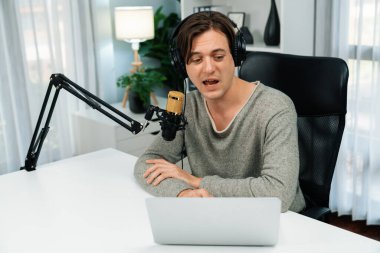 Sunucu kanalı, gülümseyen akıllı yayıncı kaydı, senaryosu ve akıllı telefonuyla sosyal medyada sohbet programı, kulaklık takarak modern ev stüdyosundaki video flamalarını kaydediyor. Bireysel.