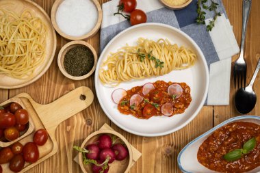 Lezzetli yiyecekler, ev yapımı spagetti, kıymalı domates sosu ve fesleğen fırlatma elementleri, şef masası dekoratif baharatlarla servis ediliyor. Varsayım.