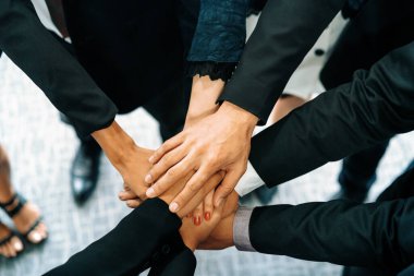 Birçok mutlu iş adamı neşe ve başarıyla el ele tutuşuyor. Şirket çalışanı başarılı bir iş projesini bitirdikten sonra kutlama yapıyor. Şirket ortaklığı ve başarı kavramı. uds