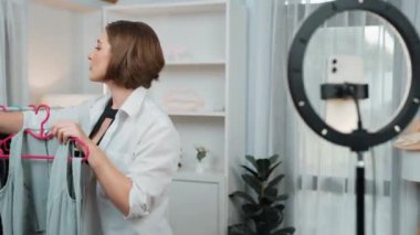 Kadın nüfuzlu kişi video görüntülerini canlı yayınlıyor. Kıyafetler sosyal medyada ya da blogda yer alıyor. Stüdyo ışıklandırmalı mutlu genç kız çevrimiçi pazarlama oturumu yayını için..