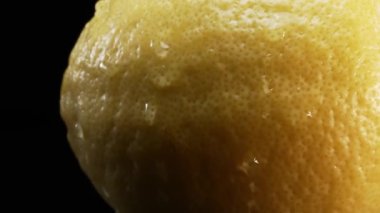 Makrografi, koyu siyah arka plana karşı taze bir limonun karmaşık dokusu sahne alır. Her yakın çekim limon yüzeyinin benzersiz desenlerini ve detaylarını yakalar. Geliştirilebilir.