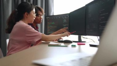 Yavaş çekim arkası yazılım geliştirici mühendisi bilgisayar programlama için birlikte çalışarak hata ayıklama kodunu çözüyor, ofiste monitörde karmaşık algoritmaları çözüyor. Filizlenen