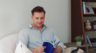 Kanepede oturan orta yaşlı bir adam, sosyal ve teknolojik mesleki gelişmeler hakkında ders kitabı okur ya da çocukları iyi bir yetişkin baba olmak için yetiştirir. Hayat boyu öğrenme konsepti. Uyumsuzluk.