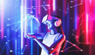 Siberpunk neon ışıklı kadın duruşu beyaz VR kulaklık takar ve metaevreleri birbirine bağlayan kolsuz tişört giyer, gelecekteki siber uzay topluluğu teknolojisi. Bir kadın 3 boyutlu küresel görüntü hologramını tutuyor ve izliyor. Halüsinasyon.