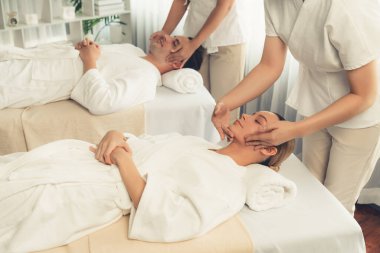 Kafkasyalı çift stres önleyici kafa masajının keyfini çıkarıyor ve lüks otellerde ya da otel spa salonlarında gündüz kaplıcalarında yüz güzelliği eğlencelerini şımartıyor. Sessiz.