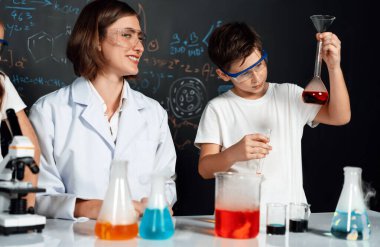 Laboratuvarda çalışan öğretmen, güvenlik gözlüğü takıyor, STEM sınıfında kimya bilimi üzerine deney yapıyor. Öğrenci komedisi tüpte sıvı deneyi yapar. Etkinlik.