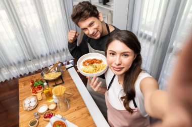 Birkaç şef etkisinde foto selfie yapmak. Domates soslu spagetti pişirmek. Kamerada özel yemek kaydı. Varsayım.