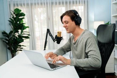 Sunucu kanalı, gülümseyen akıllı yayıncı kaydı, senaryosu ve akıllı telefonuyla sosyal medyada sohbet programı, kulaklık takarak modern ev stüdyosundaki video flamalarını kaydediyor. Bireysel.