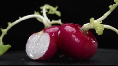 Dilimlenmiş taze turpun yakın çekimi siyah arka planda patlar. Canlı kırmızı et, karanlığa karşı bir işaret. Bu basit kompozisyon turpların eşsiz güzelliğini vurguluyor. Geliştirilebilir.