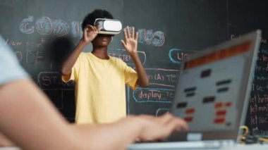 VR kullanan Afrikalı öğrenci meta-dünya ile etkileşime girerken liseli kız el kodlama programını kapat. Zeki çocuk sanal gerçeklik gözlüğü takıyor ve yenilikçi sınıfta video oyunları oynuyor. Öğretim