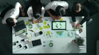 Yönetici yöneticisinin üst görünümü toplantılarda tablet temiz enerji gösterir. İş adamlarının sürdürülebilir çevre yatırımlarını planlamak ve yatırım yapmak için birlikte çalıştıklarına dair havadan bir bakış açısı. Hizalama.