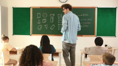 Öğrenci ödevlerine bakarken sınıfta yürüyen yetenekli bir öğretmen. Sınav yaparken ya da sınıfta ödev yaparken akıllı çocuk defterini kontrol eden profesyonel bir eğitmen. Pedagoji.