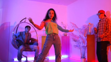 Çekici mutlu dansçı kameraya bakarken zeki kadın neon ışıkla kafiyeli hareket ediyor. Profesyonel İspanyol şarkıcı çeşitli arkadaşlarıyla renkli kıyafetler giyerken break dans yapıyor. Mutluluk.