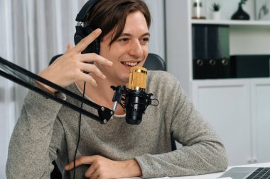 Sunucu kanalı, gülümseyen akıllı yayıncı kaydı, senaryosu ve akıllı telefonuyla sosyal medyada sohbet programı, kulaklık takarak modern ev stüdyosundaki video flamalarını kaydediyor. Bireysel.