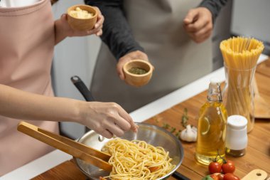 El aşçıları spagetti karışımı pişirerek tavaya baharat ve lezzetli sos koyarak ev yapımı yemek sunma kavramını geliştirir. Varsayım.