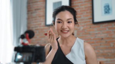 Kadın nüfuzlu kişi canlı yayın yapan video görüntülerini sosyal medya ya da blog üzerinden gözden geçiriyor. Kozmetik stüdyosu ışıklandırmalı mutlu genç kız çevrimiçi pazarlama oturumu yayını için..