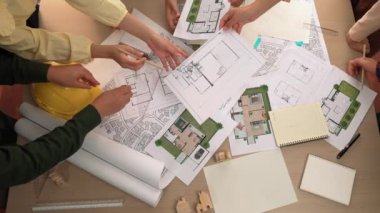 Mimari belge, ölçüm aracı ve ahşap blokların modern ofiste etrafa saçıldığı bir masa üzerinde yapı inşaatı ile ilgili mimar ve güvenlik mühendisi tartışması. Tanımlama.