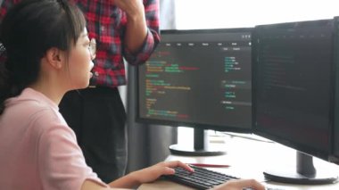 Yavaş çekimde geri uç veya yazılım geliştirici yöneticisi ekibini monitörde hata ayıklama ve karmaşık kod algoritmalarını çözmede yeni uygulama programı geliştirmede denetliyor. Filizlenen