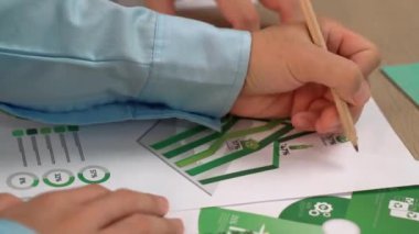 Mükemmel iş adamları, yeşil enerji grafiği kullanımı olan karmaşık bir masada eko ev projesini tartışıyor alternatif enerjiyi seçiyor ya da analiz ediyor, karbonu azaltıp dünyayı kurtarıyor. Eline odaklan. Tanımlama.