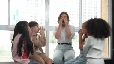 Farklı öğrencilerle çevrili yerde birlikte otururken, zeki beyaz bir öğretmen ders veriyor. Çok kültürlü bir öğrenciyle oynayan profesyonel bir eğitmen. Yaratıcı eğitim konsepti. Etkinlik.