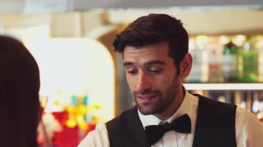 Güzel görünüşlü, zeki barmen dostu sohbet içecek barında VIP müşteriyle konuşuyor. İçki listesi tavsiye ediyor. Temiz profesyonel barmende harika bir ilk izlenim bırakıyor. Vinosity.