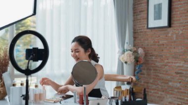 Kadın nüfuzlu kişi sosyal medya ya da blog için canlı yayın yapan video klip eleştirmeni derisini çekiyor. Canlı kozmetik stüdyosu ışıklandırması olan mutlu genç bir kız pazarlama için internet üzerinden yayın yapıyor..