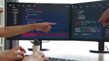 Yavaş çekim arkası yazılım geliştirici mühendisi bilgisayar programlama için birlikte çalışarak hata ayıklama kodunu çözüyor, ofiste monitörde karmaşık algoritmaları çözüyor. Filizlenen