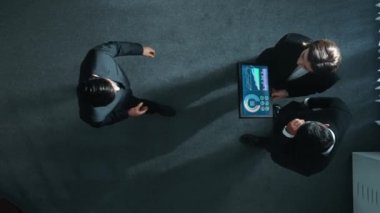 Profesyonel iş adamının yukarıdan görünüşü bir ekibe katıldı ve yönetici müdürle tokalaştı. Akıllı pazarlama ekibi tabletteki yatırım verilerini analiz etmek için birlikte çalışıyor. Müdürlük.