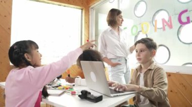 Akıllı öğretmen öğrencilere elektrikli aletin bir kısmını açıklamak için cam tahta kullanıyor. Çeşitli çocuklar elektronik aletleri öğrenir ve ana kartı ya da robotu tamir ederken dizüstü bilgisayar kullanır. Etkinlik.