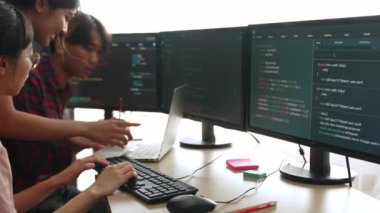 Yavaş çekim arkası yazılım geliştirici mühendisi bilgisayar programlama için birlikte çalışarak hata ayıklama kodunu çözüyor, ofiste monitörde karmaşık algoritmaları çözüyor. Filizlenen