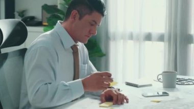 Profesyonel mühendis, türbin motoru veya jet motoru tasarımı ve çeşitli metal teçhizat dağılımı ile toplantı masasında yeşil ekranlı tablet üzerinde çalışırken telefona bakıyor. Hizalama.