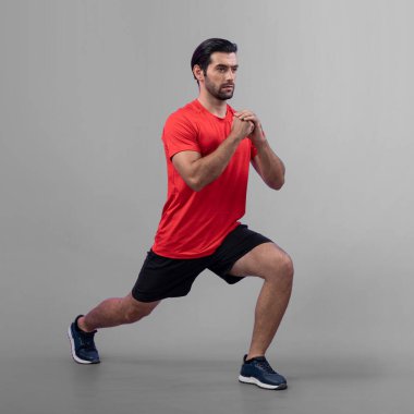 Vücut uzunluğunun tamamı atletik ve sportif genç bir adam tarafından izole edilmiş arka planda egzersiz pozisyonunda çekilmiştir. Sağlıklı aktif ve vücut bakımı yaşam tarzı.