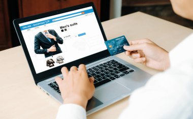 Genç adam, laptop bilgisayar başvurusu ya da web sitesinde online alışveriş yapmak için kredi kartı kullanıyor. E-ticaret ve online alışveriş konsepti. uds