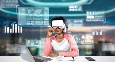 Masada ödev yaparken yapay zeka kullanarak metaevreleri birbirine bağlayan dizüstü bilgisayar ve artırılmış gözlük kullanan bir kız. Öğrenci holograma bakıyor ve bulanık ofiste oturuyor. Yaratıcılık.