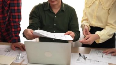 Akıllı mimar ve güvenlik mühendisi, mimari belge, ölçüm araçları ve ahşap blokların modern ofiste etrafa saçıldığı masa planlarını tartışıyor. - Yakın çekim. Tanımlama.